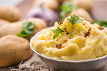Mashed potatoes in bowl decorated with parsley herbs.