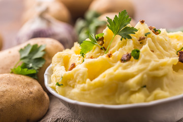 Mashed potatoes in bowl decorated with parsley herbs.