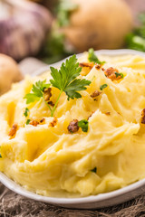 Mashed potatoes in bowl decorated with parsley herbs.