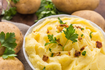 Mashed potatoes in bowl decorated with parsley herbs.