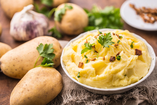 Mashed potatoes in bowl decorated with parsley herbs.