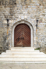 Fototapeta na wymiar gate with steps of castle with stone wall in Budva Old Town, Montenegro