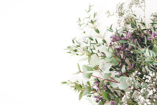 Fototapeta Wedding, birthday styled stock photo. Feminine scene, floral composition. Bunch of eucalyptus branches, baby's breath Gypsophila and limonium flowers. White table background. Flat lay, top view.