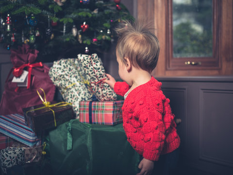 Cute little boy opening christmas presents