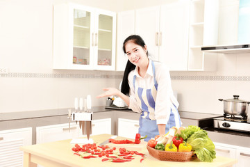 Obraz na płótnie Canvas Asian housekeeper smiles in modern kitchen