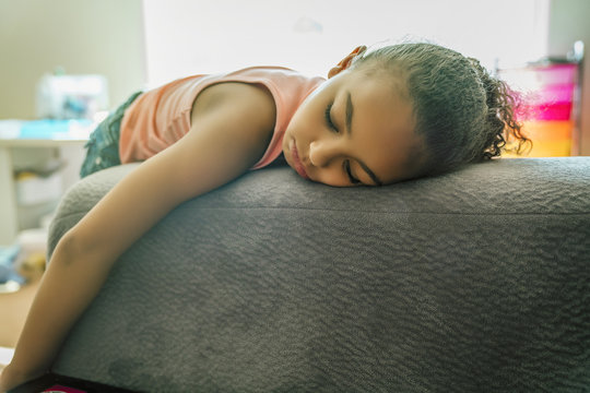Bored mixed-race girl pouting on couch