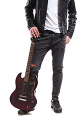 Naklejka premium legs of rocker holding his guitar on ground