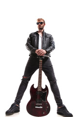 dominant guitarist in leather jacket holding his guitar