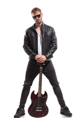 handsome rock star posing while holding his guitar