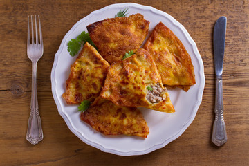 Savory stuffed crepes with meat. Pancakes filled with meat. View from above, top studio shot