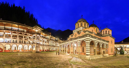 Fototapeta premium Beautiful panoramic panorama at night of the Orthodox Rila Monastery, a famous tourist attraction and cultural heritage monument in the Rila Nature Park mountains in Bulgaria