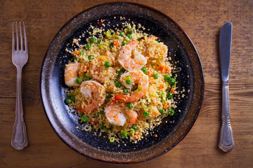 Shrimps with couscous, green peas, leeks and carrot. overhead, horizontal