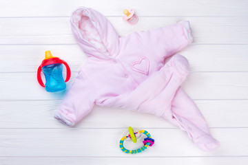 Pink baby girl fleece coverall and toys.