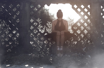 Adult ballerina sitting in nature