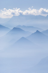 Blue layers of mountain ridges in the french alps with clouds