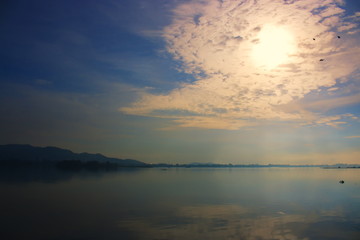 The sun with the clouds reflected in the river.