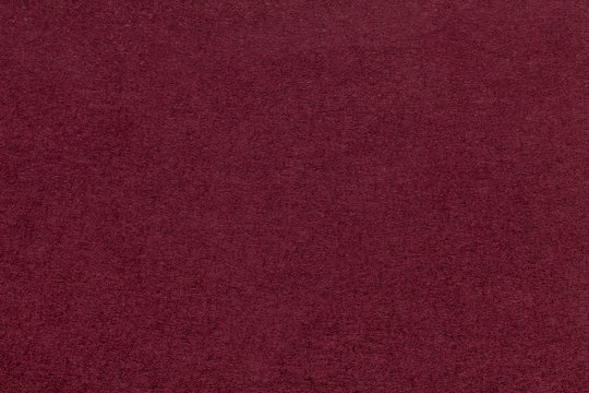Texture of old dark red paper closeup. Structure of a dense cardboard. The maroon background.
