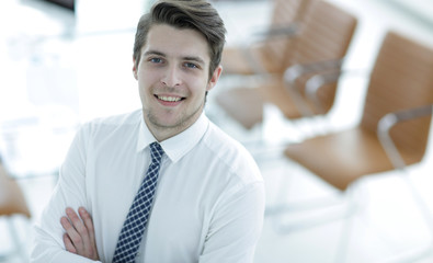 confident young businessman on background of office