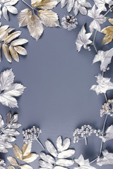 Winter concept flat lay with golden and silver leaves. Christmas frame background. Top view
