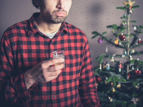 Sad and depressed man with drink at christmas