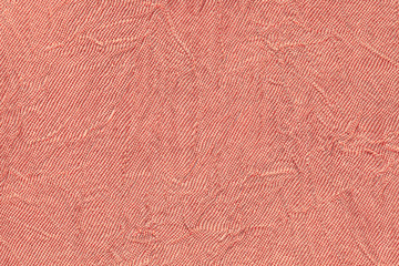 Fototapeta premium Light red wavy background from a textile material. Fabric with fold texture closeup.