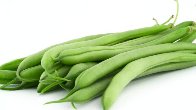 Macro shooting of a green beans pile. Rotating on the turntable isolated on the white background. Close up. Macro.