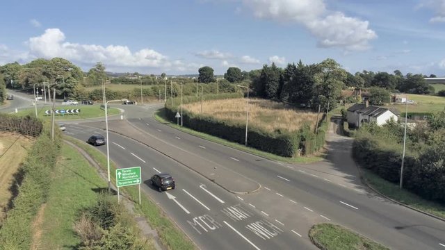 Aerial view, rise up move. Road and roundabout near Tarvin, small town among cheshire plains