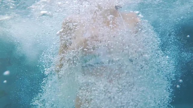 Slowmotion Footage of a woman jumping into a pool