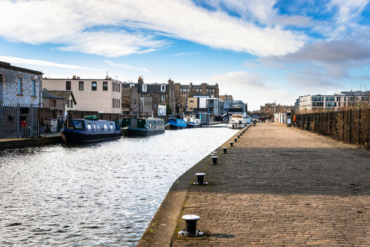 Cobblestone Quay along a Canal and Moored Canal Boatson a Sunny Winter Day. Edinburgh, Scotland