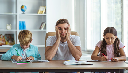 The angry father with kids doing homework at the desk
