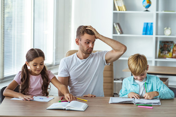 The angry father with kids doing homework at the desk