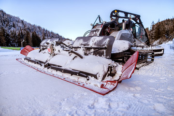 Bulldozer cleaning snow on mountain. Making road clean for car.