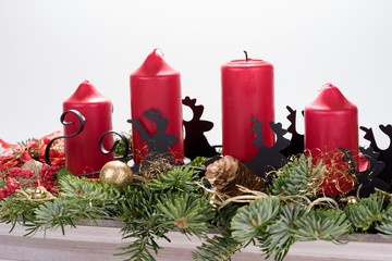 Four traditional red advent candles with christmas decoration. Isolated on white background