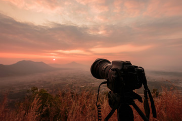 Landscape DSLR camera on tripod with a lot of fog Phu Thok Mountain at Chiang Khan ,Loei Province in Thailand.