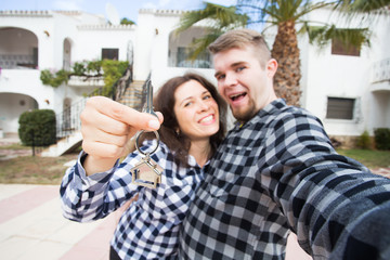 Real estate - happy couple showing keys of their new house