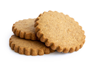 A pile of three round gingerbread biscuits isolated on white. Serrated edge.