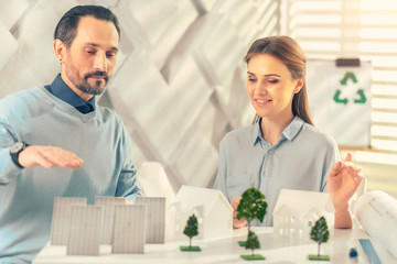 Have a look. Attentive female sitting at her workplace while listening to her partner