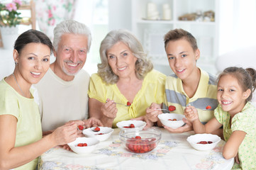 Portrait of big happy family eating fresh strawberries