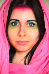 Young caucasian woman with colorful makeup and pink head shawl