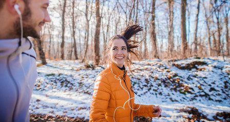 Fitness couple winter morning exercise at snowy mountain.