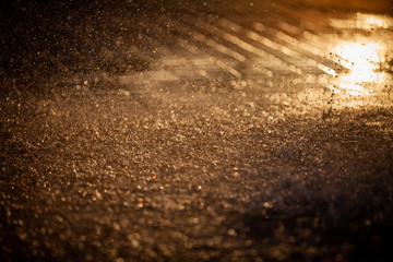 Splashes of water and bokeh of Water on a Sunset Background.