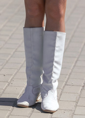 Legs of a girl in white leather boots