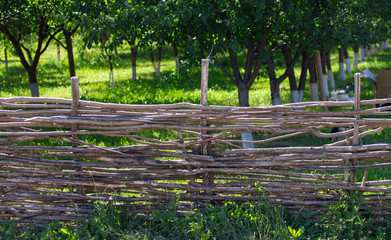 Fence of wooden branches in the garden