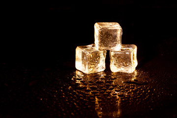 Golden ice cubes on black background.