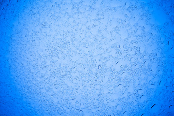 Rain droplets on blue glass background, Water drops on blue glass.