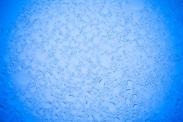 Rain droplets on blue glass background, Water drops on blue glass.