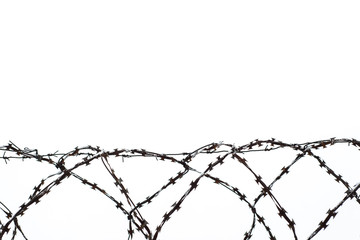 restriction of liberty: metal barbed wire on the background of winter sky