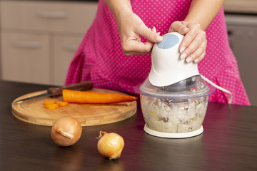 Woman turning on an onion chopper