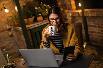 Evening work. Middle aged woman using tablet.