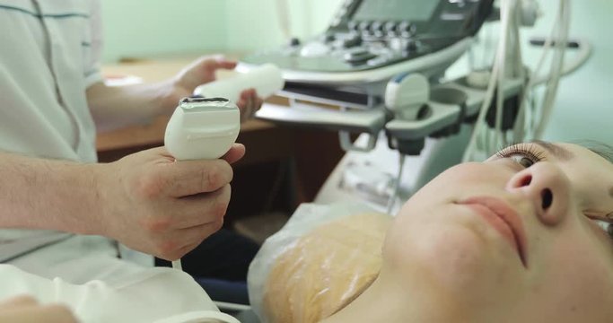 Doctor checks pathyroid and thyroid with ultrasound machine.